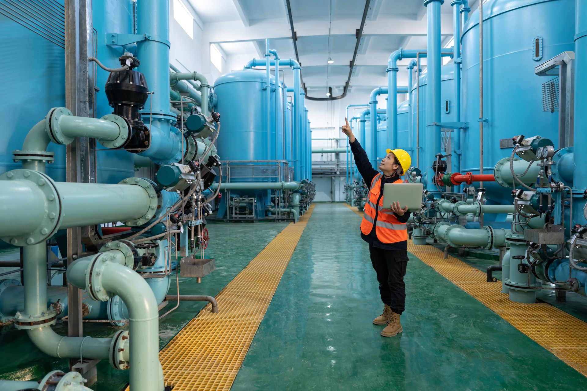 A female engineer works in a chemical plant using a laptop computer